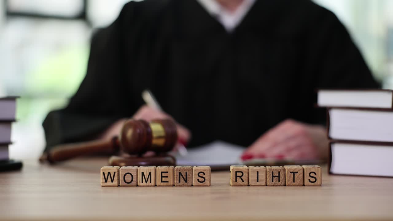 Judge and gavel on desk with 'WOMENS RIHTS' blocks symbolizing legal rights
