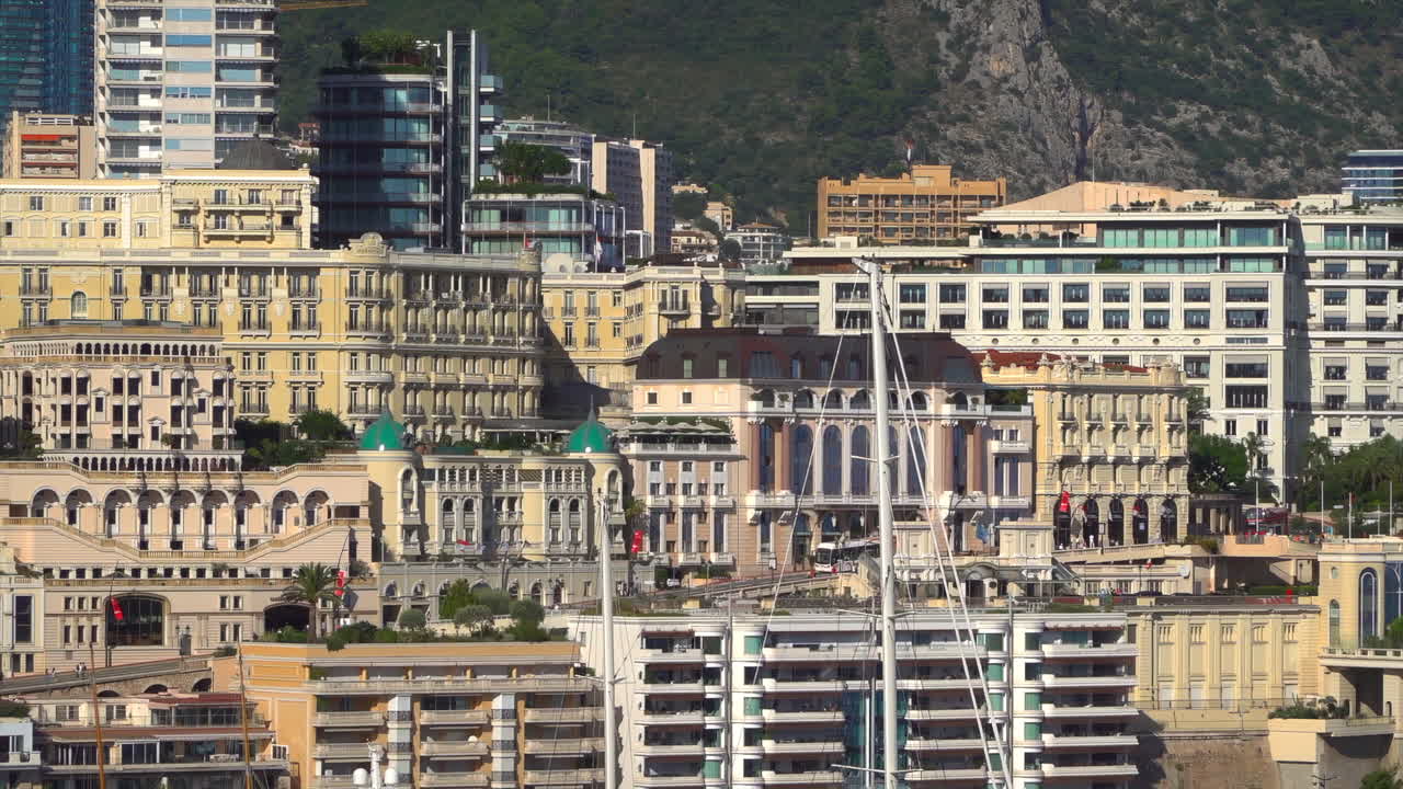 Monte Carlo, Monaco - July 4, 2025: View of buildings, high-rise towers, and bustling marina filled with luxury yachts, framed by the surrounding mountains