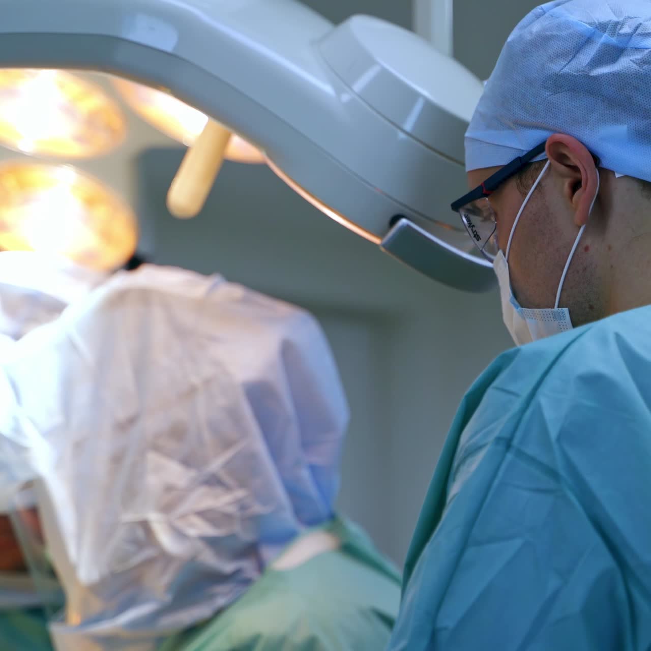 Un gran equipo quirúrgico en el quirófano. Vista posterior de un médico mirando el trabajo de los cirujanos.