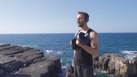 muscular young man lifting weights outdoors.