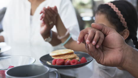 biracial woman and child enjoy breakfast, the woman clapping