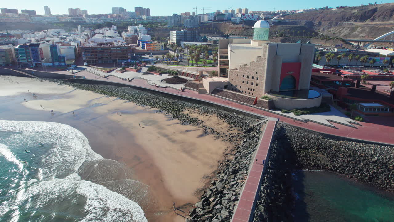 воздушный вид на прибрежный город с пляжем и современным зданием