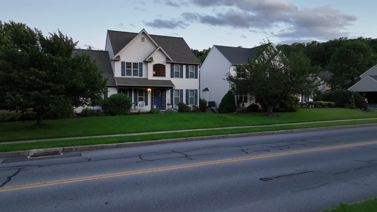 Colonial or craftsman single family house in suburb of American town. Aerial view. Dusk scene with green Grass in front yard. Pennsylvanian village, USA.