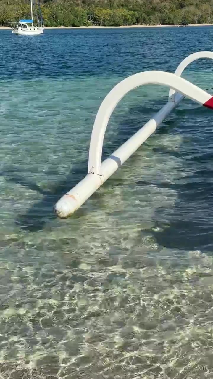 Outrigger Boat Floating in Clear Tropical Shallow Water