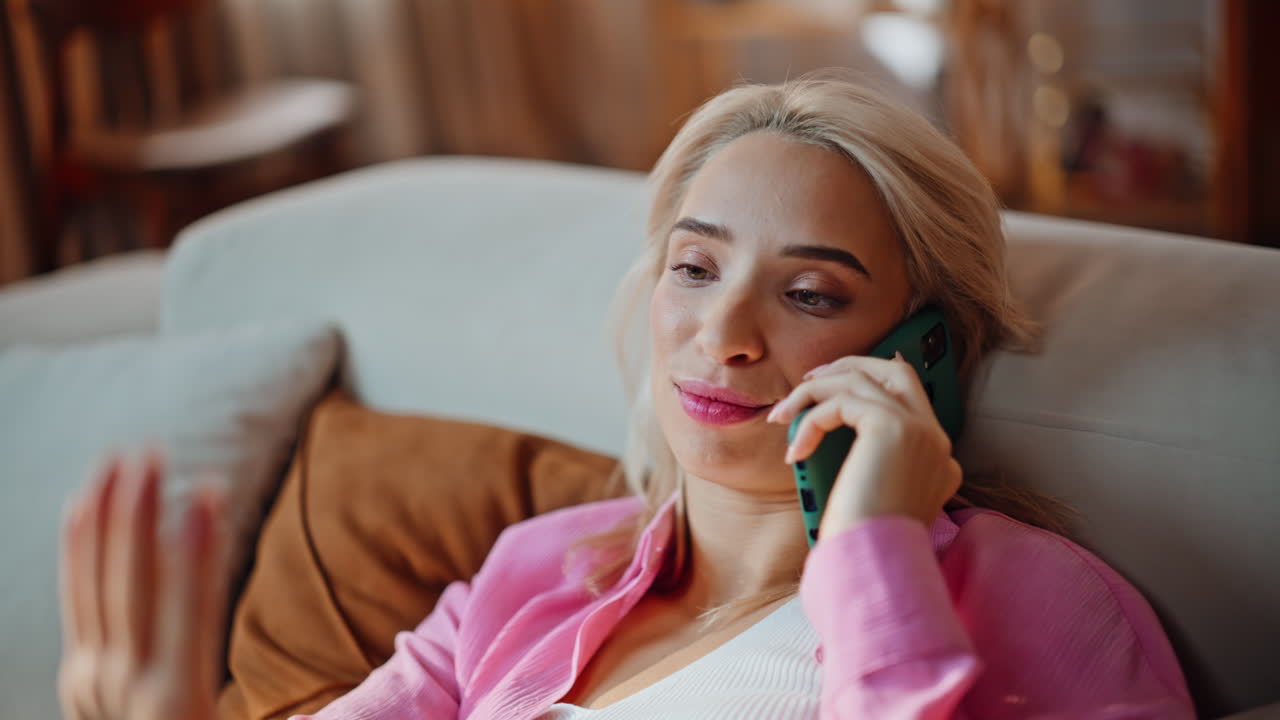 Closeup blonde talking cellphone at comfortable apartment sofa. Lady chilling