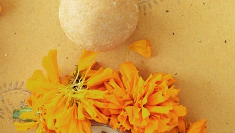 tilt across indian sweets, flowers, diyas on a indian background for hindu festival of lights, dusshera and diwali preparation and celebration ingredients