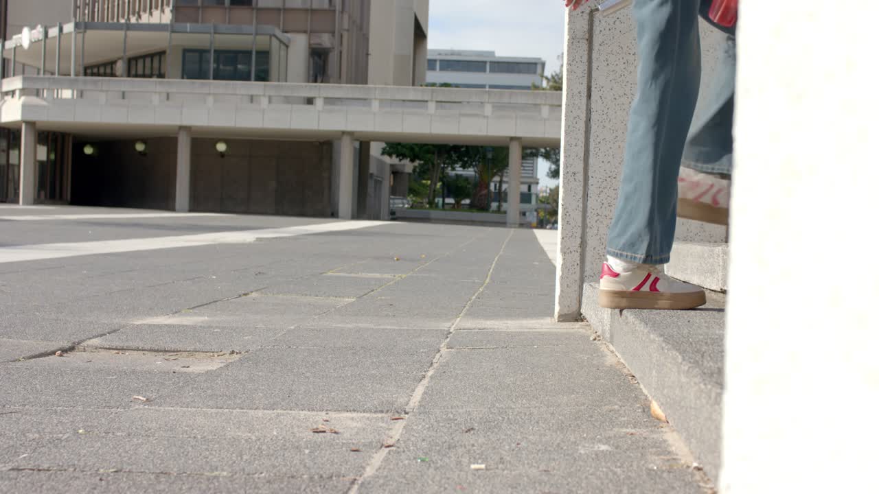 O temporizador marcando três segundos, uma mulher entrando na praça com uma bebida vermelha e subindo um degrau de concreto.