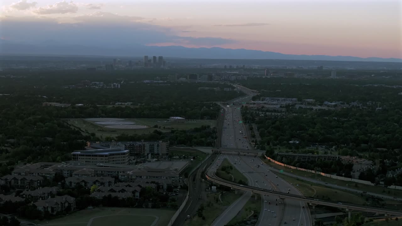 Downtown Denver i25 car truck traffic DTC Denver Tech Center Centennial cityscape aerial drone Colorado golden hour sunset clouds Lone Tree Aurora RTD lightrail Front Range Rocky Mountains forward pan