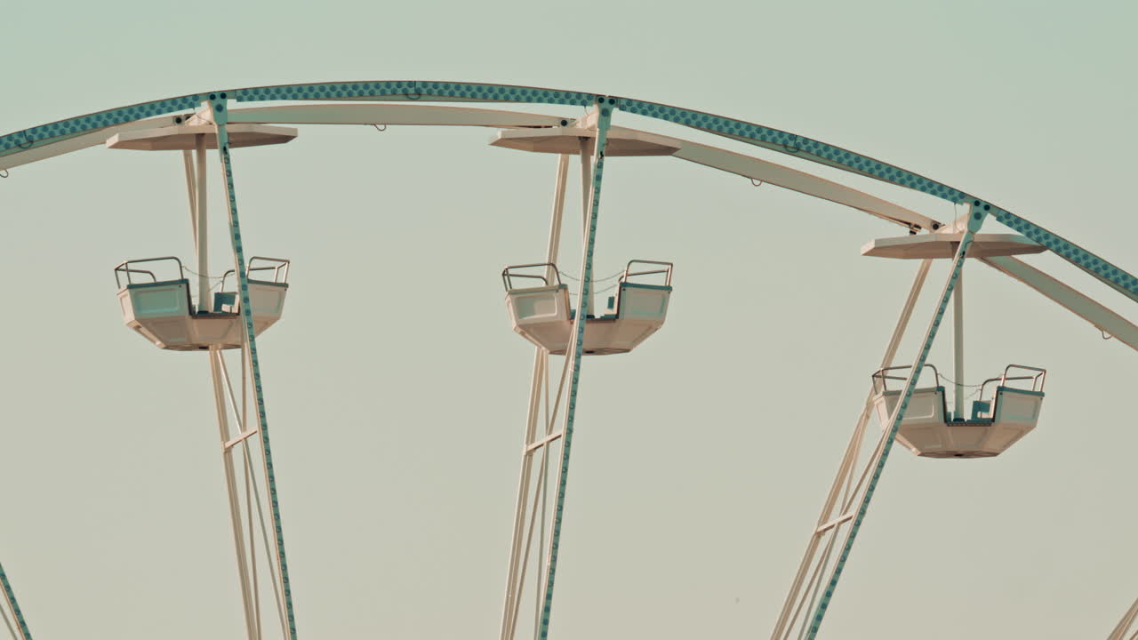 Close up of the Ferris wheel cabins and metal beams, emphasizing the geometric lines