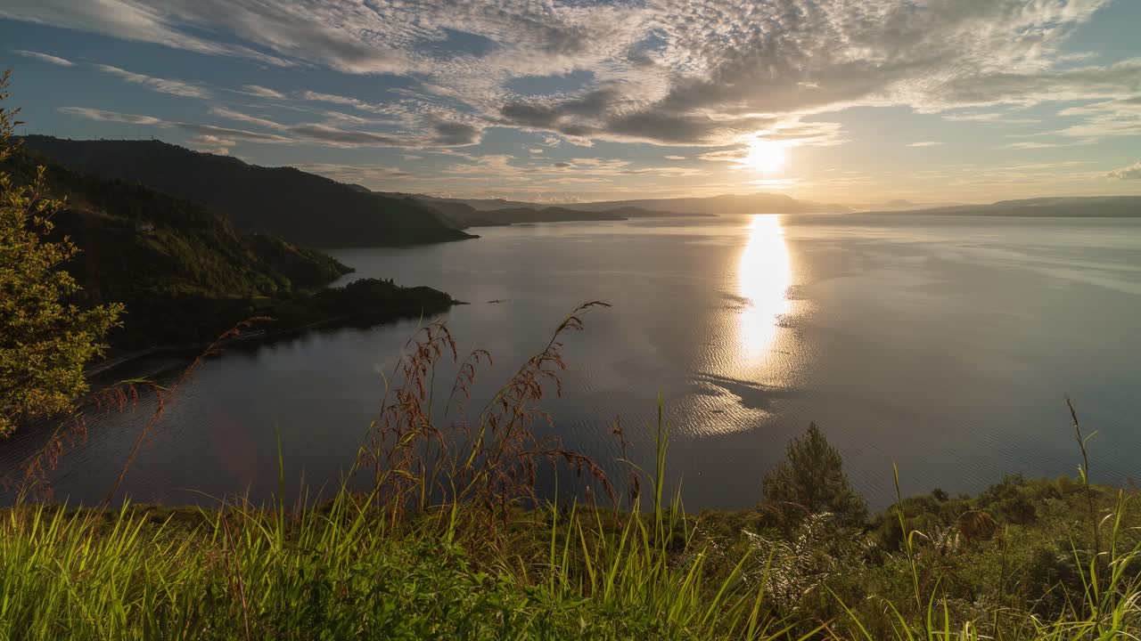 Tramonto dorato su un vasto lago circondato da montagne