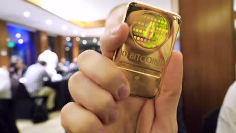 holding a physical bitcoin gold bar