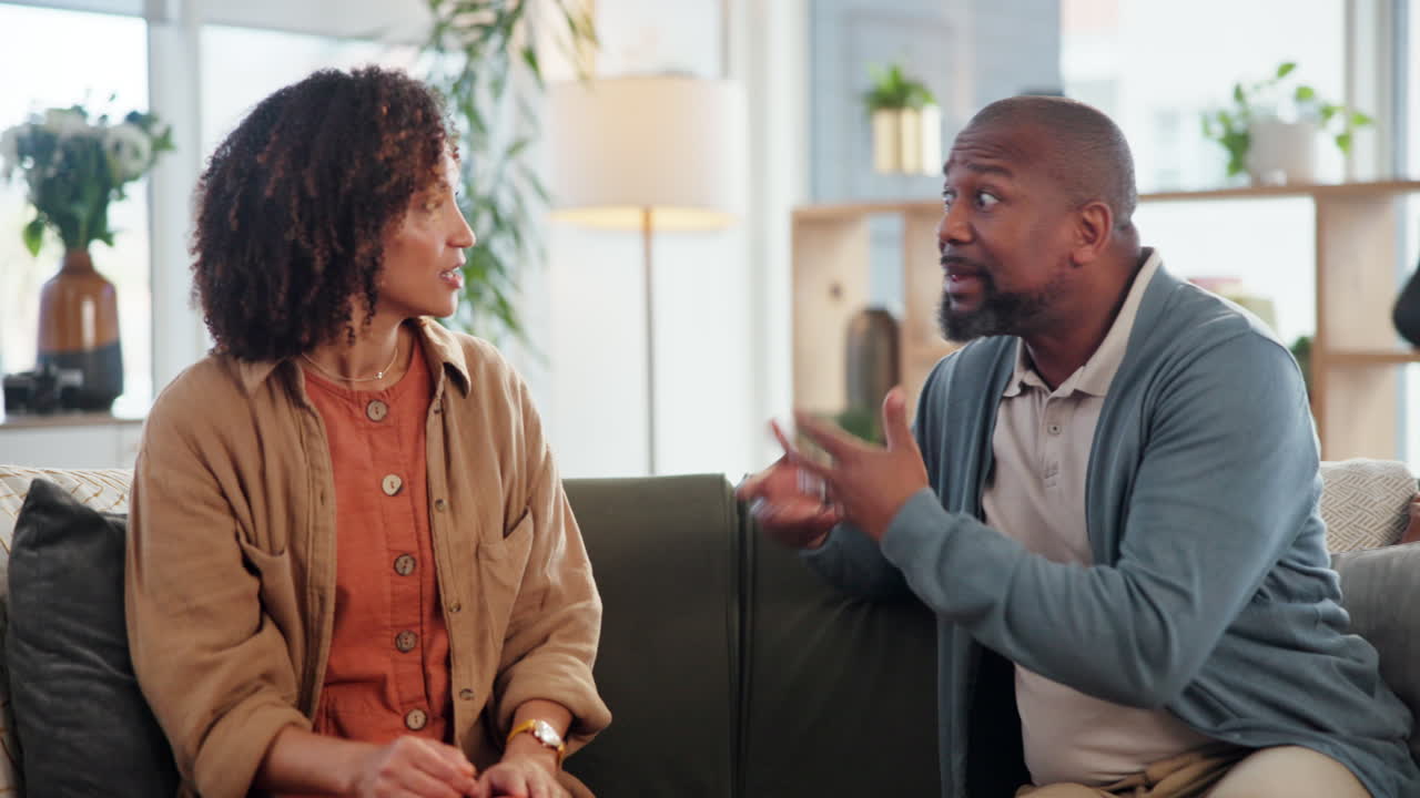 una pareja discutiendo en el sofá.