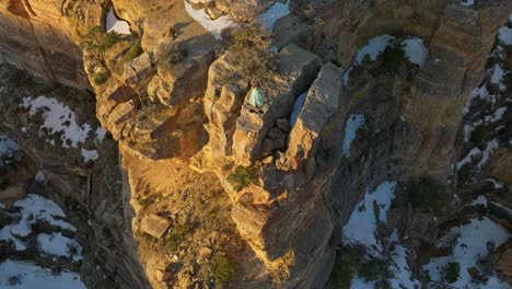 Above-View-Of-A-Person-Standing-On-Sedimentary-Rock-Cliffs-Of-The-Grand-Canyon-National-Park-In-Arizona,-United-States