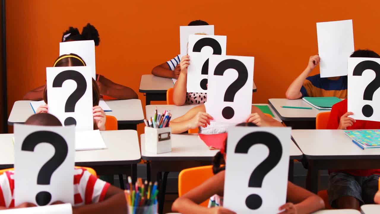 niños de la escuela cubriendo su cara con un signo de interrogación