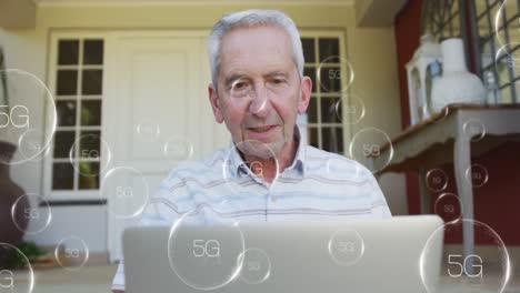 animación de iconos de 5g cayendo sobre un hombre mayor caucásico que usa una computadora portátil