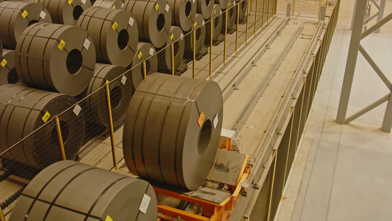 Close up of a transportation system driving heavy steel coils through an automated warehouse