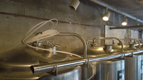 slow pan down row of steel brewing tanks in suncheon, south korea brewery