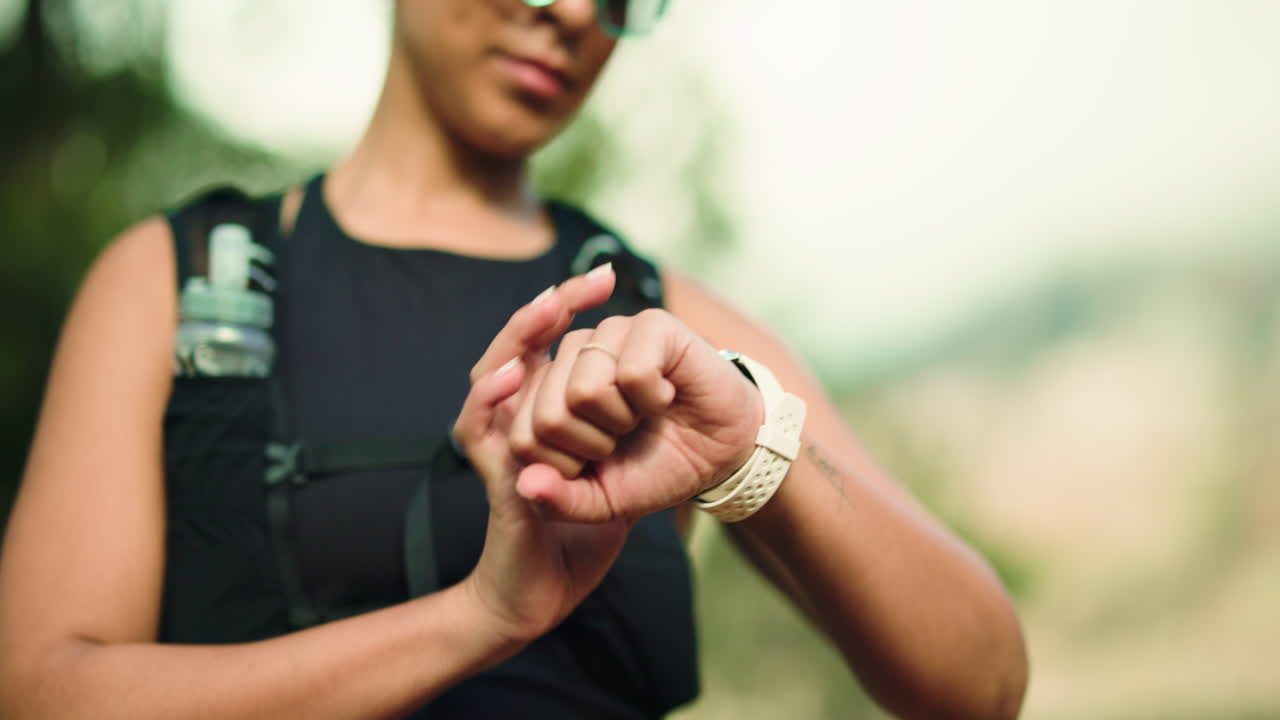 Athletic woman checking her smartwatch outdoors