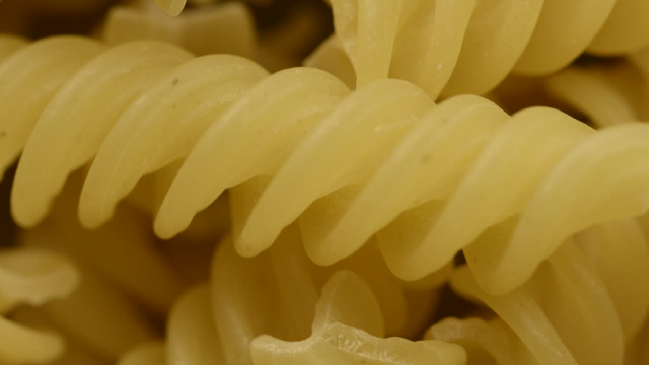 un primer plano de la pasta italiana de fusilli en bruto girando en círculo
