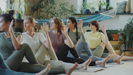 women practicing seated twist pose on yoga lesson