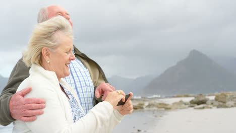 side view of old caucasian senior couple taking selfie with mobile phone at beach 4k