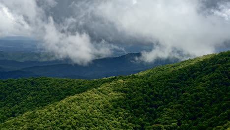 drone soars over mountains where fog and rain blur the line between sky and land