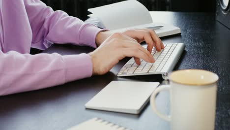 person typing on keyboard at desk