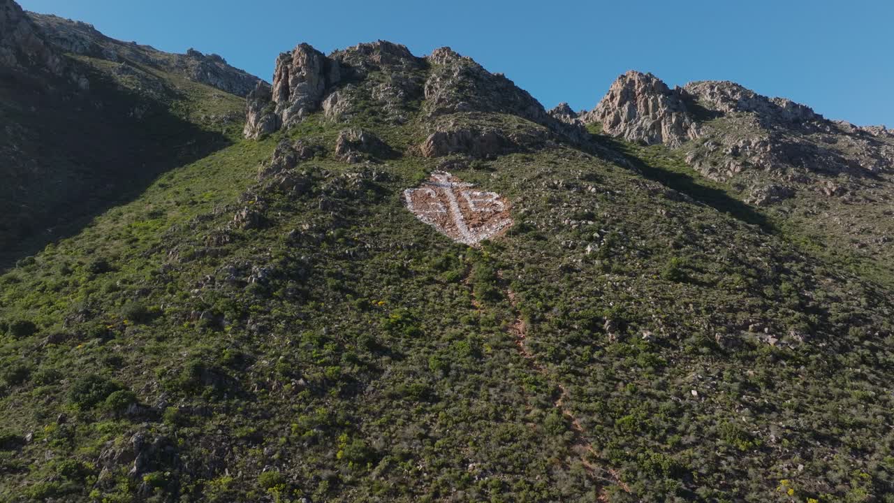 una vista aérea panorámica de la bahía de gordons, que muestra montañas verdes exuberantes y cielos despejados