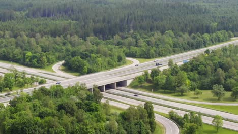 timelapse of fast driving cars at a german highway with curved exit lanes and a slow zoom out, filmed by a drone from above