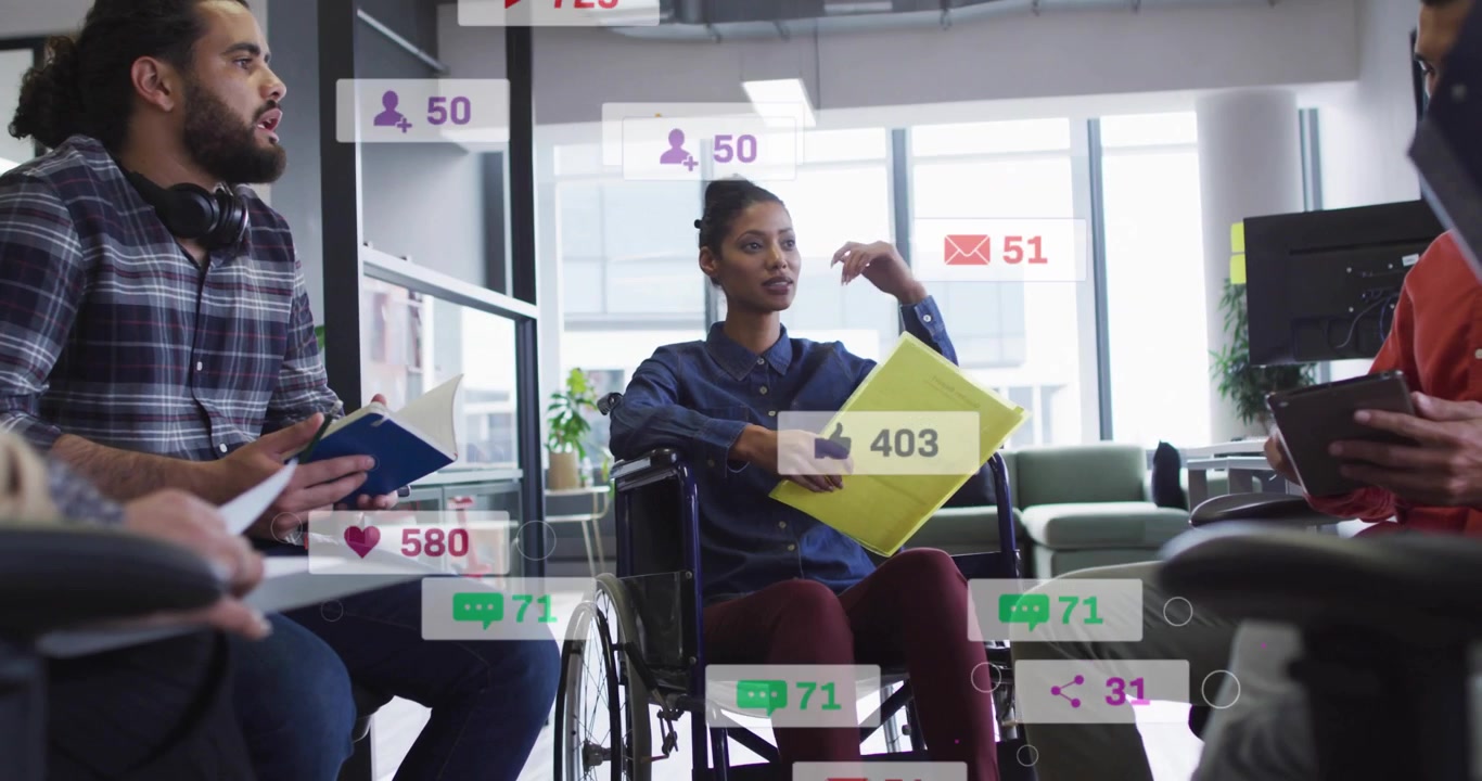 Woman in wheelchair leading marketing team speaking gesturing, causing social badges flooding frame