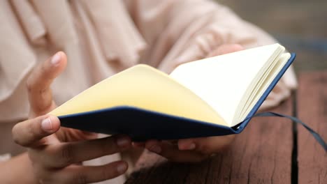 close up of women hand turning a pager of a diary ,