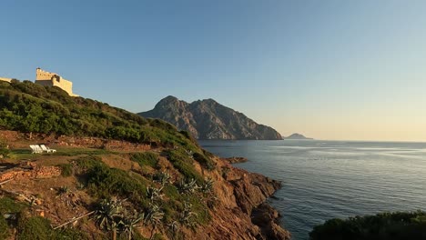 vista panorámica del castillo de girolata y tumbonas frente al mar