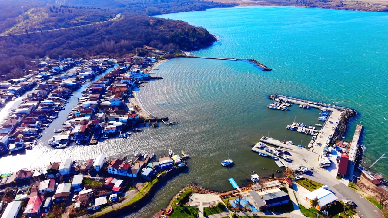 Kıyı limanının, tekneli iskelelerin ve konut iskelelerinin kuşbakışı görünümü. Deniz kenarı marinasının ve balıkçı kulübelerinin drone çekimi, Burgas, Bulgaristan.