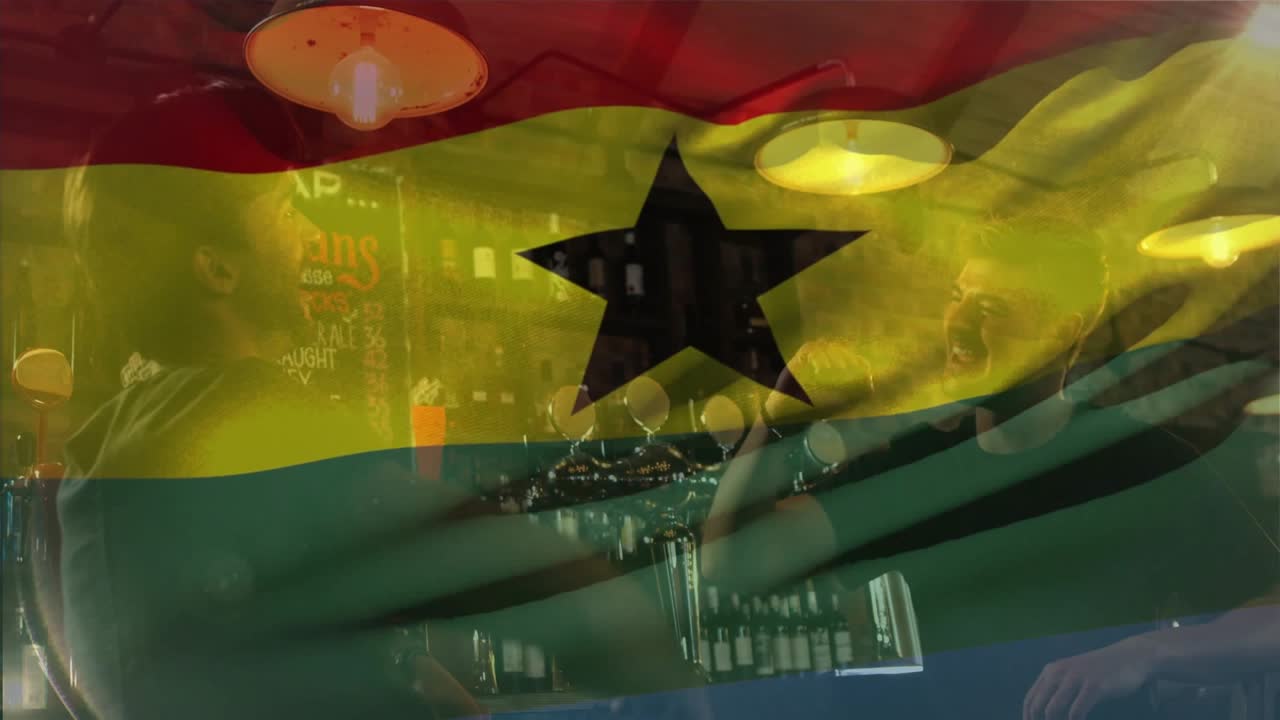 Due uomini si chinano, gesticolano e sorseggiano al bar, la bandiera del Ghana appare e sventola, promozione dell'ospitalità.