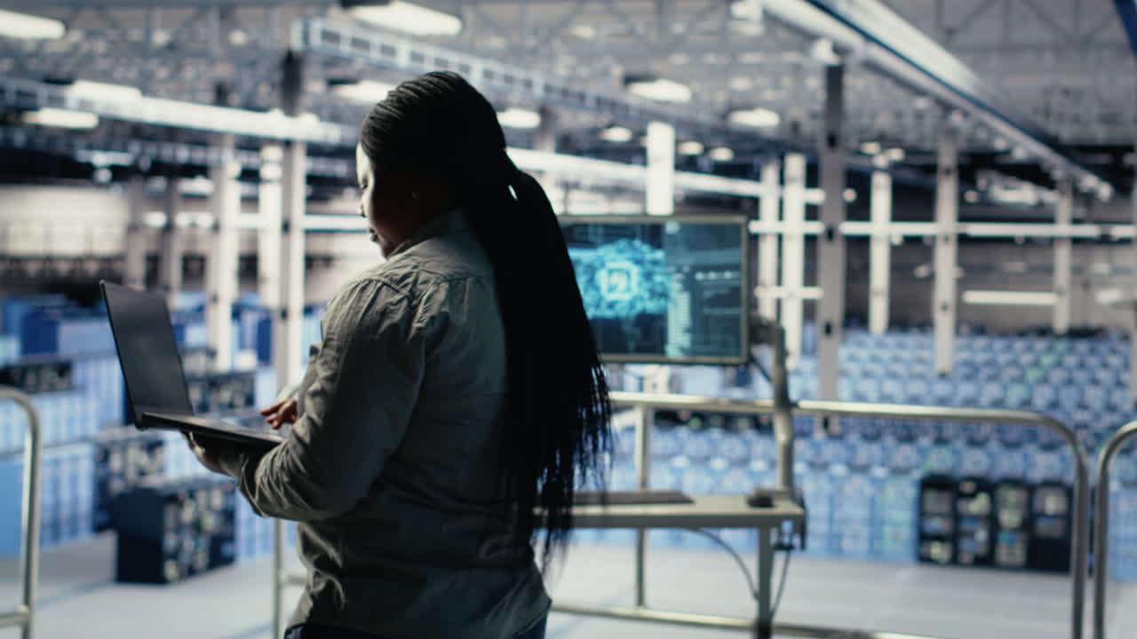 It Expert Monitors Server Farm Activity Using Laptop While Walking In Facility