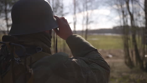 soldier with binoculars in a forest