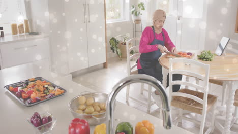 Mujer-Birracial-Con-Hijab-Cortando-Verduras-En-La-Cocina,-Cocinando-Sobre-Puntos-De-Luz