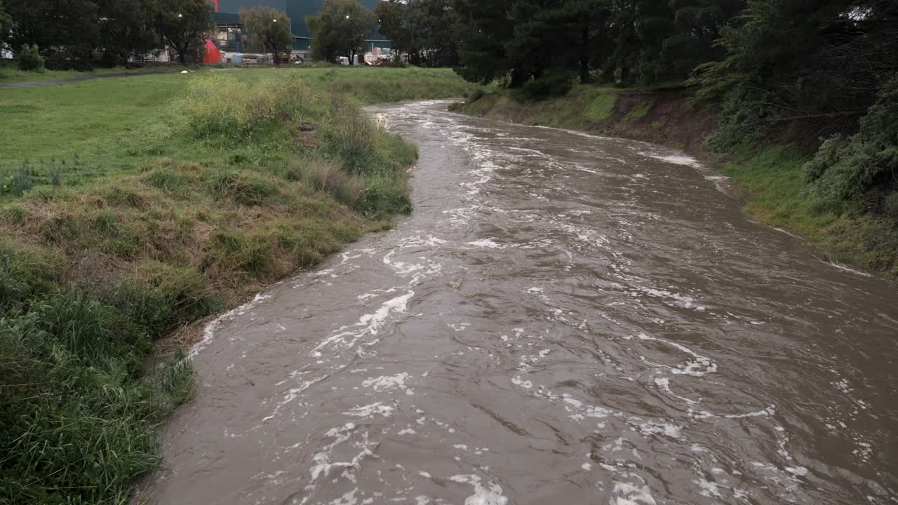 Water flowing rapidly downstream after torrential rainfall in Waurn Ponds , Australia