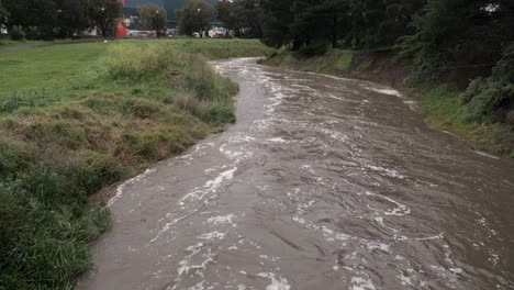 el agua que fluye rápidamente río abajo después de las lluvias torrenciales en los estanques de waurn, australia