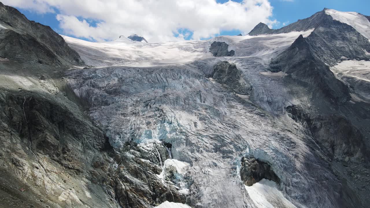스위스 모리 빙하의 웅장한 공중 풍경, 푸른 하늘 아래의 놀라운 얼음 형태와 산꼭대기