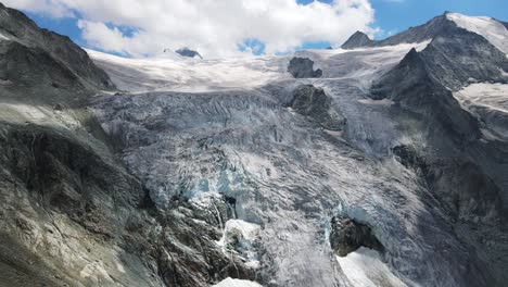 majestuosa vista aérea del glaciar moiry en suiza con impresionantes formaciones de hielo y picos de montañas bajo un cielo azul