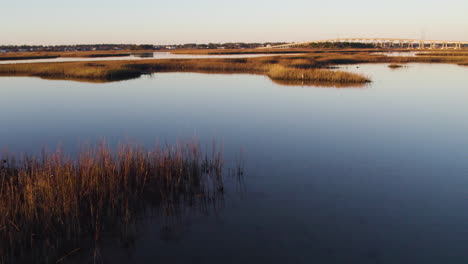 Drone-shot-of-sun-setting-on-the-Bogue-Sound,-low-aerial-footage-of-coastal-sunset