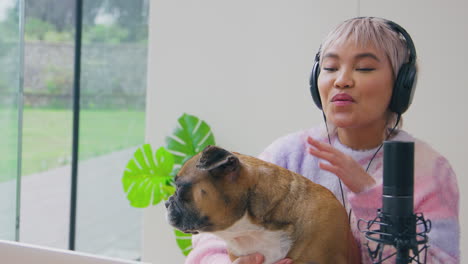 Mujer-Con-Mascota-Bulldog-Francés-Grabando-Podcast-O-Transmitiendo-Por-Radio-En-El-Estudio-En-Casa