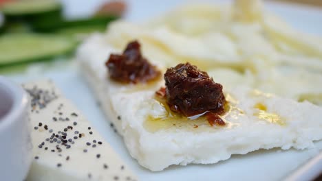 cheese platter with dried tomato dip and cucumber