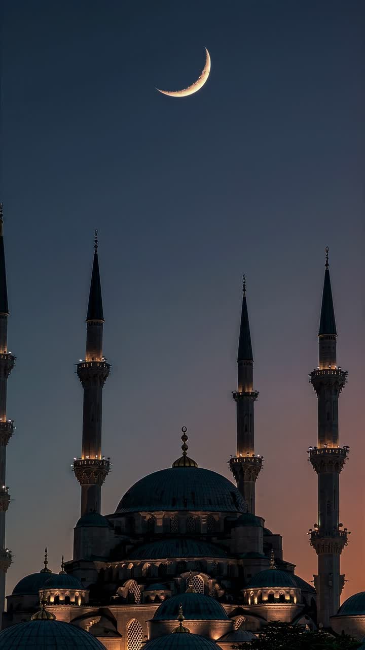 Un'inquadratura dal basso cattura la silhouette di una moschea contro un cielo crepuscolare con una luna crescente