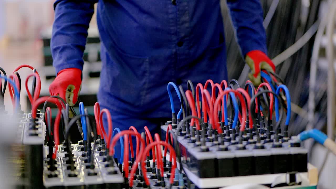 한 사람이 배터리에 케이블을 설치합니다.