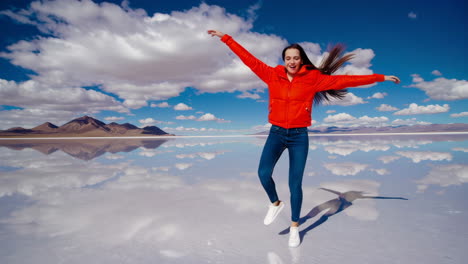 woman jumping and posing on a reflective salt flat