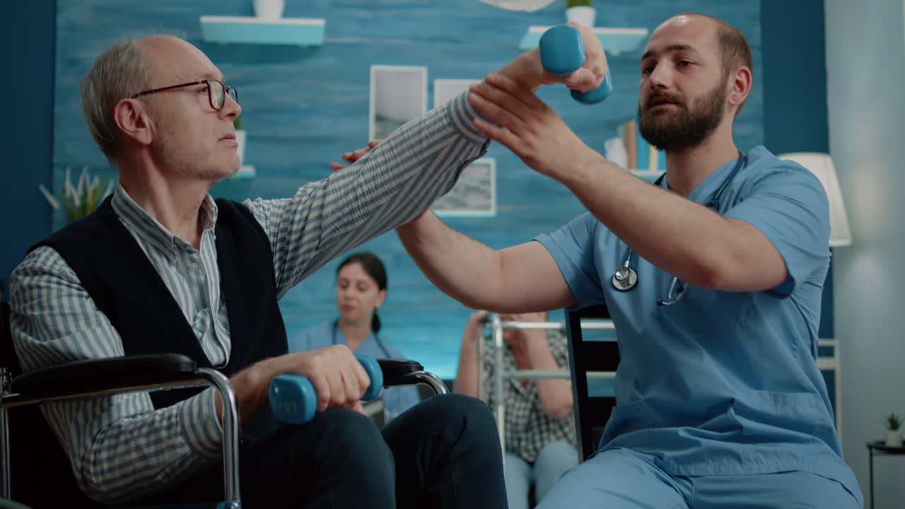 Nurse helping disabled man to exercise with dumbbells