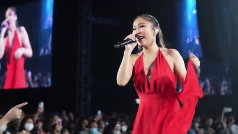 dynamic performance of a talented singer dressed in red, captivating the audience with emotion and passion during an electrifying live concert experience