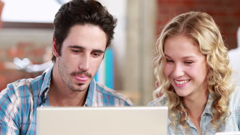 Casual-business-team-using-laptop-at-desk